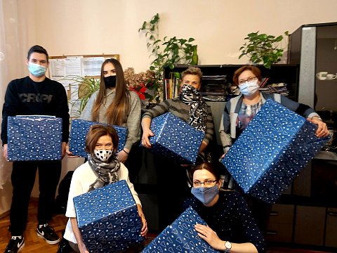 Zdjęcie. Uczniowie i nauczyciel trzymają zapakowane paczki.