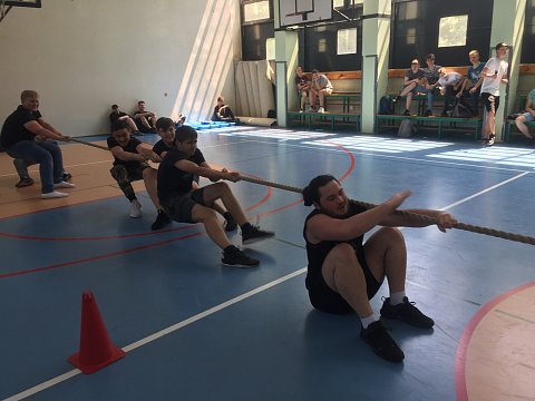 Uczniowie na sali gimnastycznej podczas przeciągania liny.