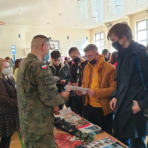 Zdjęcie z targów. Uczniowie przeglądają oferty.