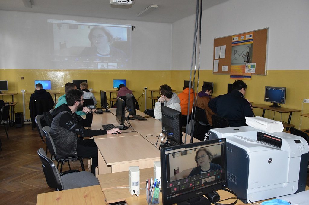 Uczniowie w sali komputerowej. Za pośrednictwem Internetu przemawia do nich Dyrektor szkoły.