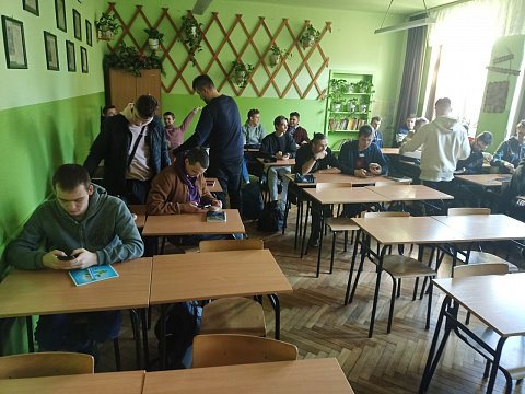 Sala lekcyjna. Jeden z uczniów rozdaje pączki.