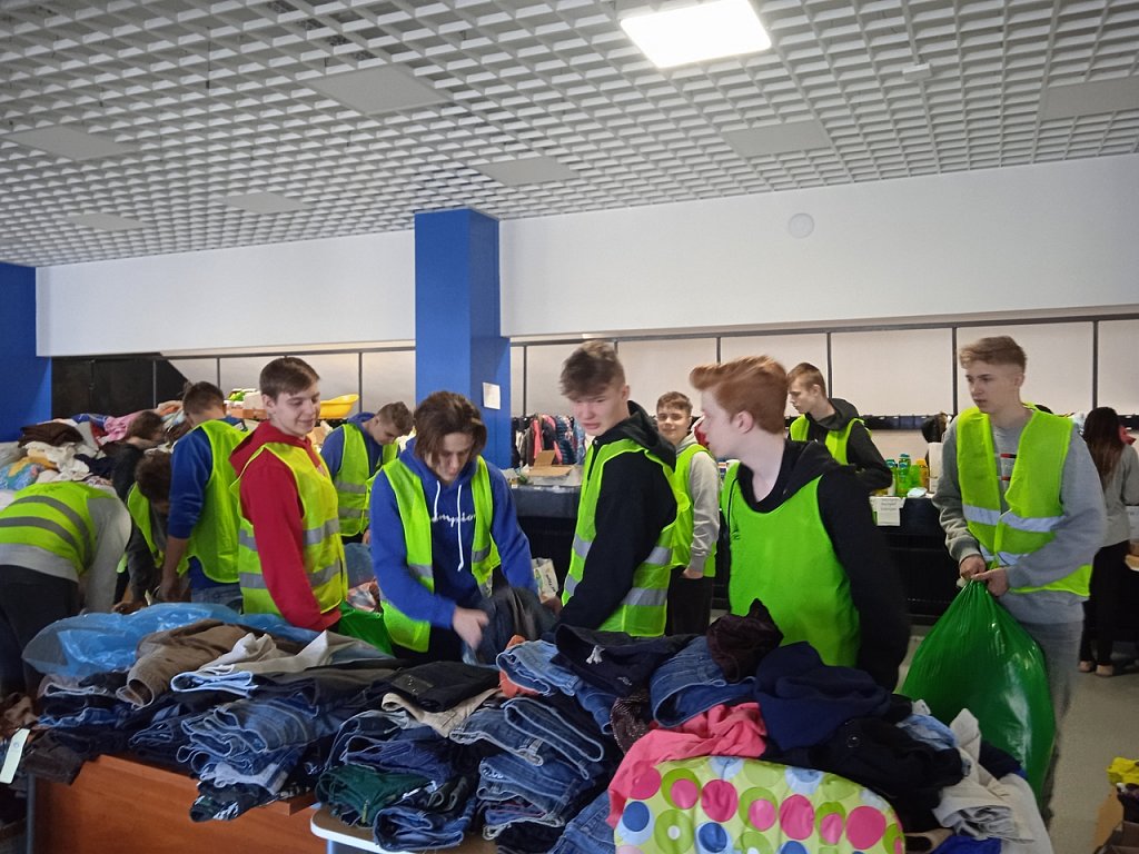 Uczniowie pracują w ramach wolontariatu przy sortowaniu odzieży.
