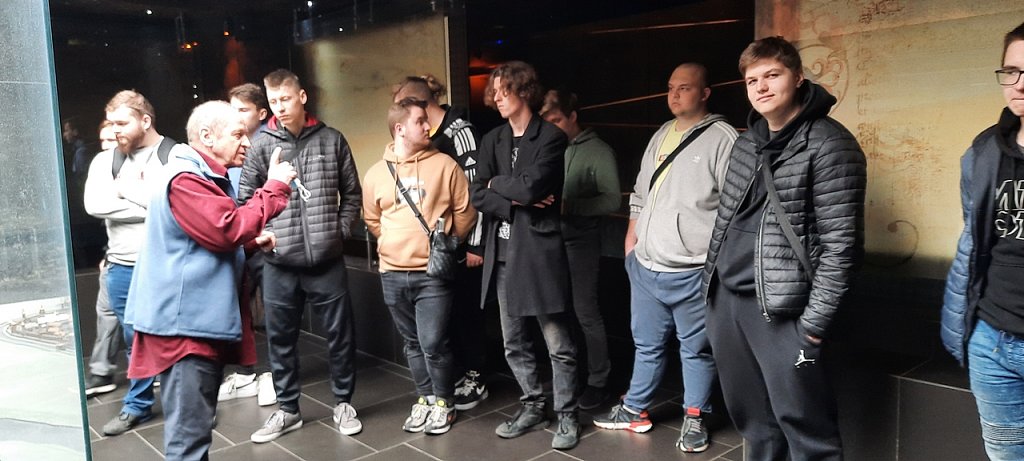 Grupa uczniów przed nimi stoi przewodnik.