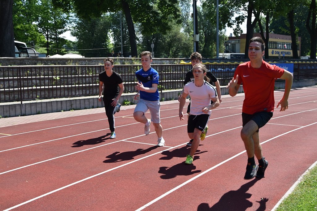 Piątka uczniów na bieżni stadionu.