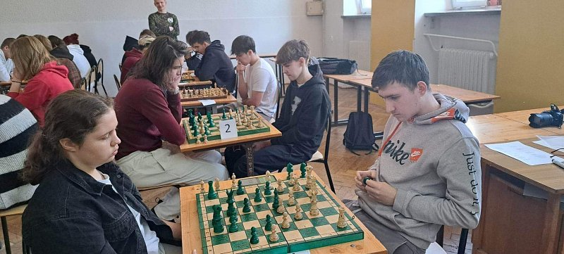 Stolika na których ustawiono szachy 4 drużyny w rzędzie rozgrywają mecze. 