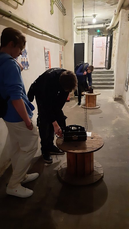 Uczniowie sprawdzają jak działał w czasach PRL telefon. 